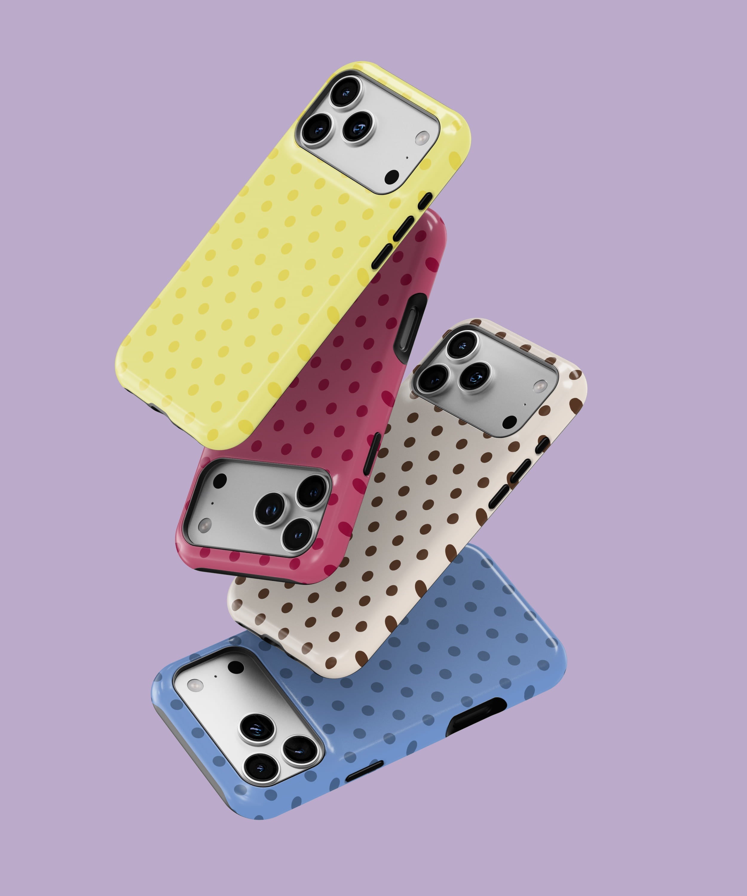 Stacked polka dot phone cases in yellow, pink, brown, and blue, each featuring small contrasting dots. The cases are arranged in a floating, angled stack against a soft lavender background.