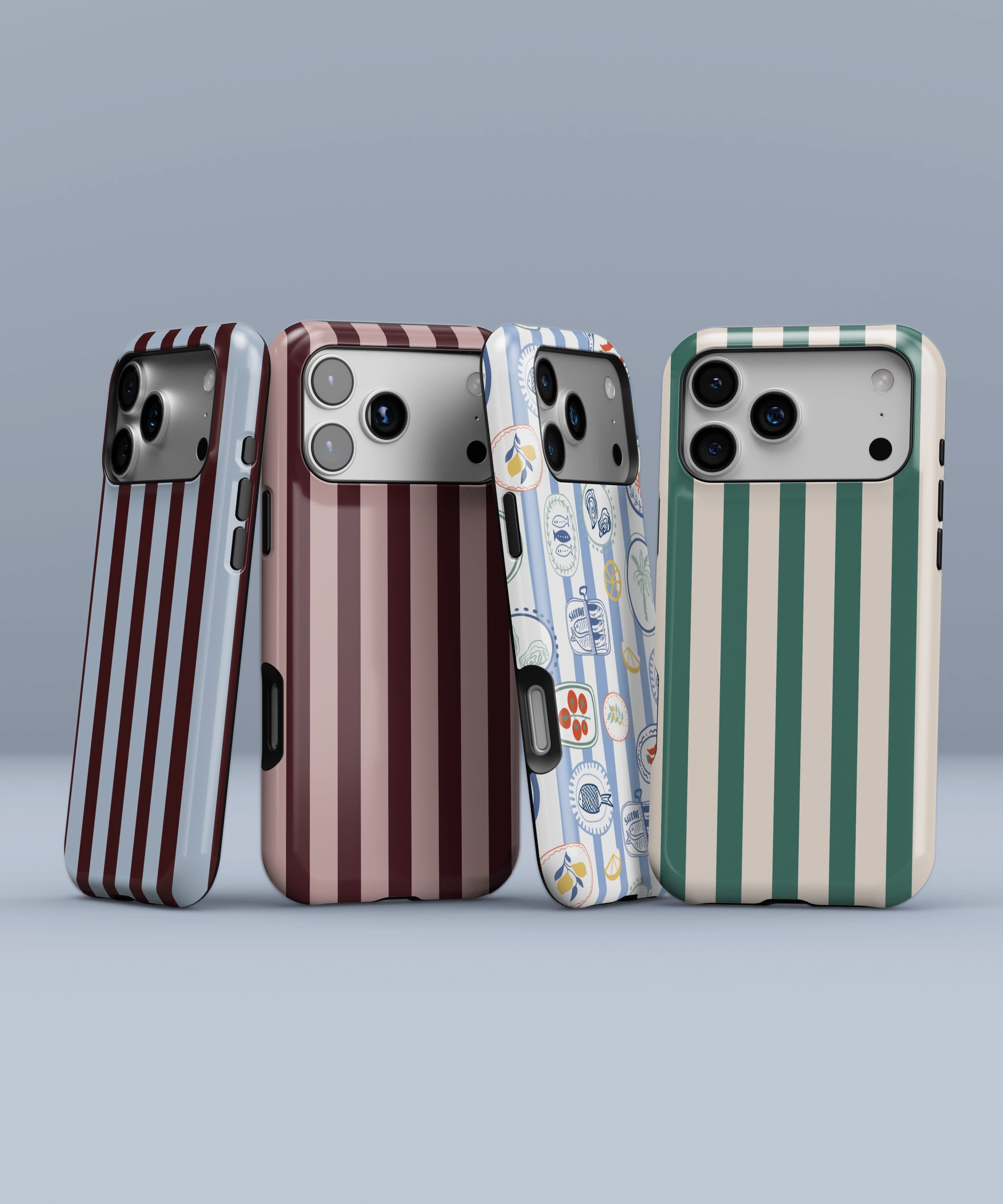 Four striped phone cases displayed side by side against a soft blue background, featuring burgundy and light blue stripes, burgundy and blush stripes, a blue Mediterranean tile pattern, and green and cream vertical stripes.